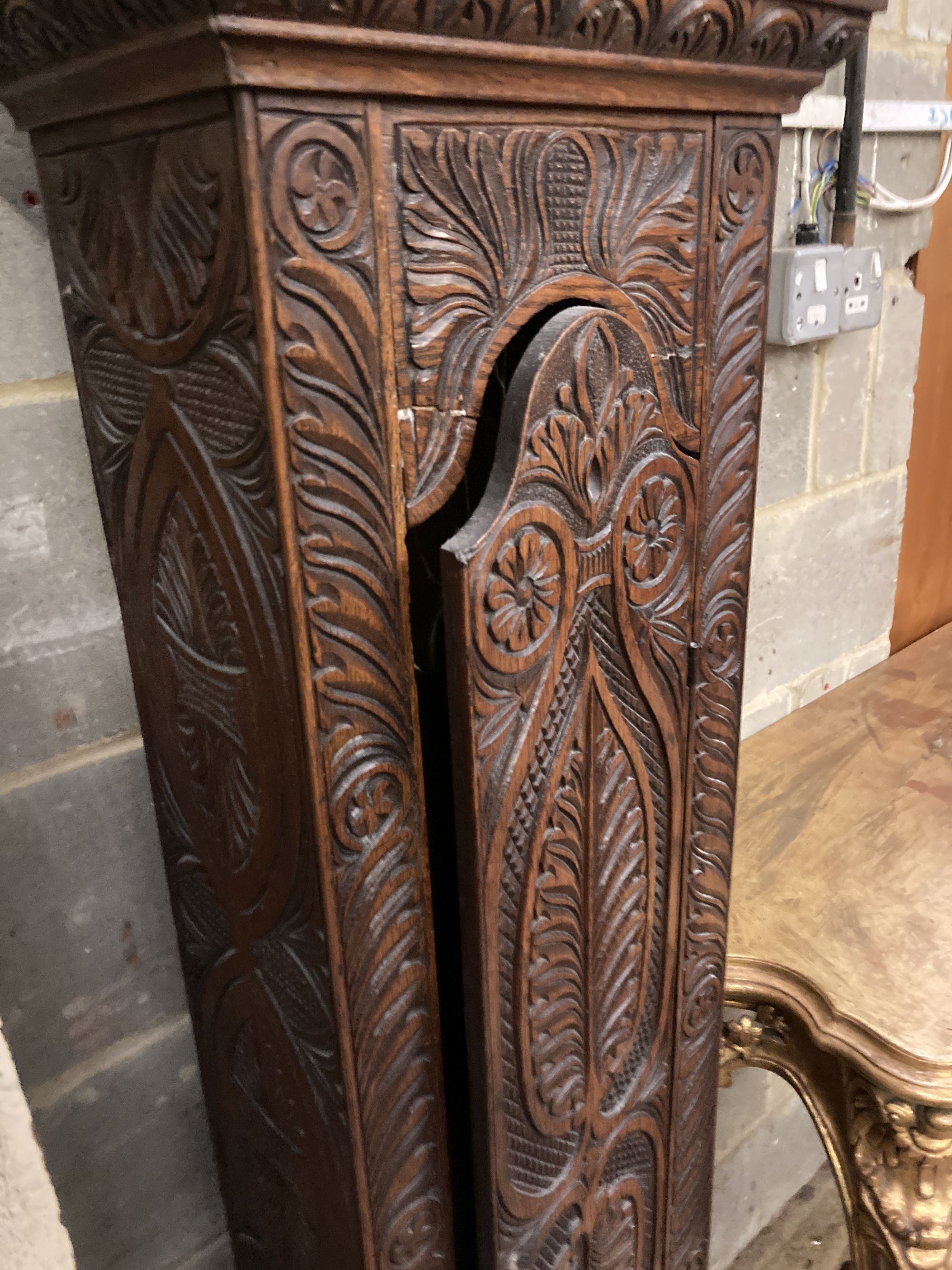 Simon Worley of Starton - an early 18th century 8 day longcase clock, contained in a later carved oak vase, height 210cm